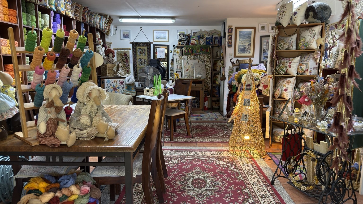 Vista interior de El Atelier del Bordado con lanas, cojines y proyectos