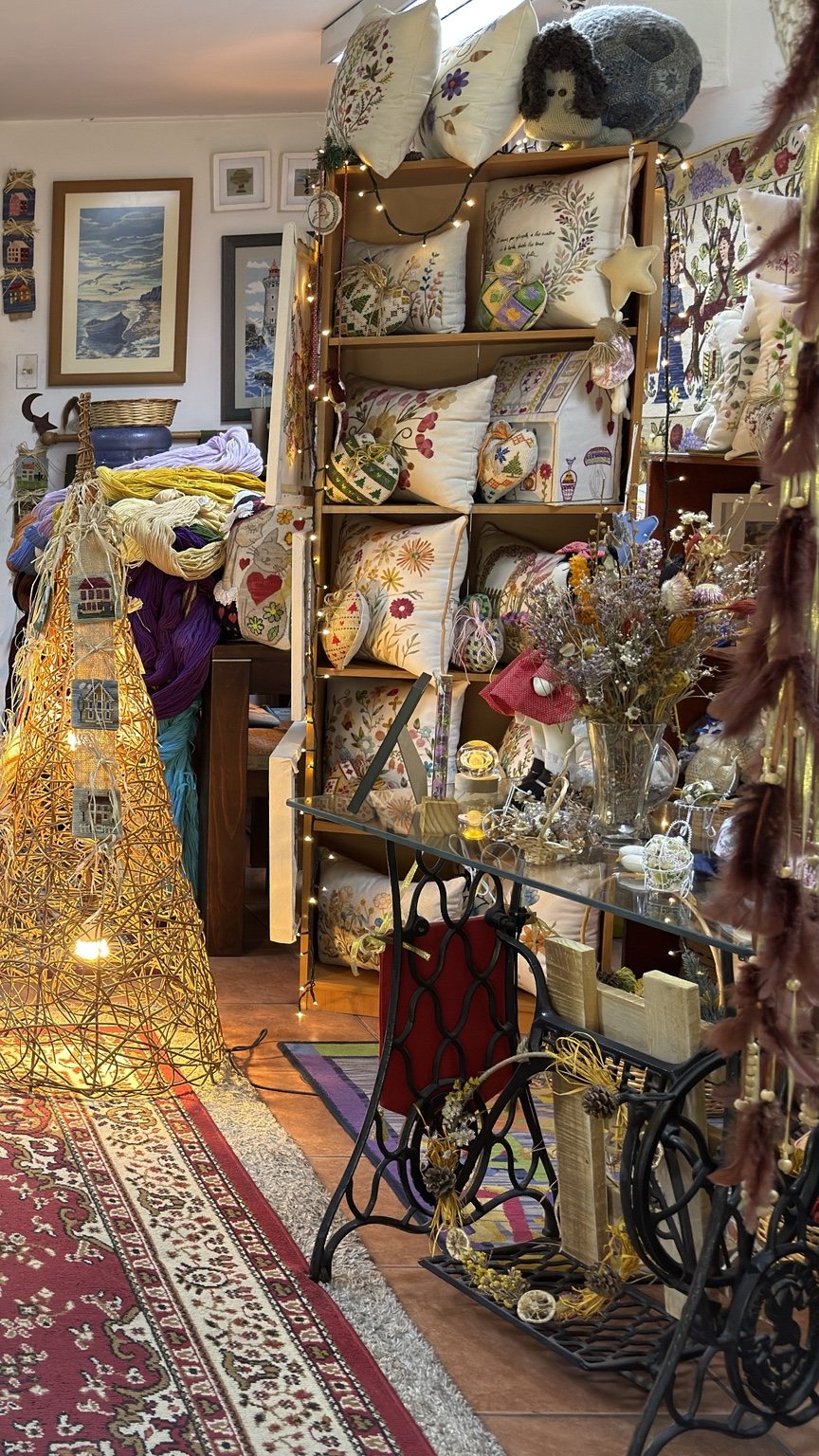 Interior de El Atelier del Bordado con cojines, lanas y proyectos artesanales